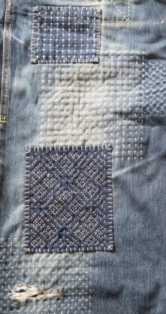 an old pair of blue jeans with holes in the back pocket and stitching on them