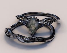 a silver ring with a heart shaped stone on it's center and twisted design around the band