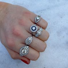 a woman's hand with three rings and an evil eye on the ring finger