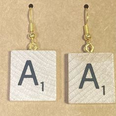 two small square earrings with letters on them