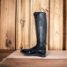 a pair of black boots sitting on top of a wooden table