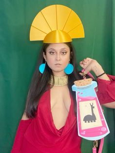 a woman in a red dress is holding a wine bottle and wearing a paper hat