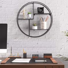 a computer desk with a clock on the wall above it and plants in vases