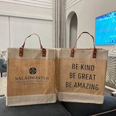 two jute bags sitting on top of a black chair in front of a tv