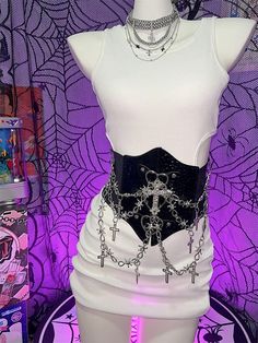 Elevate your style with this edgy Y2K-inspired corset belt, featuring a captivating punk aesthetic. Adorned with intricate cross charms and a bold heart design, this statement piece effortlessly combines rebellious flair with a touch of romance. The belt is enhanced with eye-catching chains that add an extra layer of attitude. Crafted for comfort and versatility, the back of the corset belt is equipped with a convenient Velcro closure. The elastic material provides just the right amount of stretch. Edgy Festival Corset For Halloween, Edgy Halloween Festival Corset, Punk Party Corset, Alternative Style Halloween Corset For Concerts, Gothic Corset With Belt For Cosplay, Halloween Corset For Concert, Black Edgy Corset Belt For Halloween, Punk Halloween Corset For Concerts, Halloween Punk Style Corset For Concert