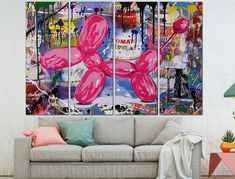 a living room with a couch and two paintings on the wall, one is pink