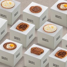 many square boxes with different types of pastries on top of each one, including an egg in the middle