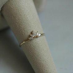 a close up of a ring on a white cloth with a small diamond in the middle