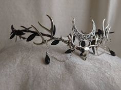 This gorgeous tiara features a haunting, yet beautiful dear skull underneath a filigree crescent moon. Two antlers adorn each side of the dear skull, and delicate chains and crystals fall from the antlers. Leaves surround the flexible branch-like base, and the piece is adjustable with a ribbon in the back. Perfect for cosplay, renaissance fairs, special occasions, or to add a little magic to your everyday! The primary color refers to the leaf and crystal color. Shadow And Bone Halloween Costume, Witchy Wedding Crown, Goth Wedding On A Budget, Moon Based Outfits, Forest Witch Headpiece, Vampire Asethic Outfits, Woodland Goth Aesthetic, Antler Tiara, Dark Faerie Costume