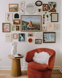 an orange chair sitting in front of a wall filled with pictures and other things on it