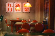 an empty restaurant with red chairs and tables in front of two chinese characters on the wall