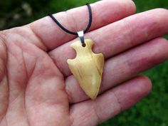 I hand-carved this one-of-a-kind arrowhead pendant from Exotic Italian Olive wood. It's fully carved in the round on both sides so you can hang either way. I like the look of primitive arrowheads so I do my carvings to emulate that style.  A hand rub finish is applied and then the pendant is buffed to a buttery smooth final finish that feels amazing to the touch.  You can choose from a variety of necklace/cording options including: 18" or 22" stainless steel chain A variety of colors of satin co Rustic Arrowhead Necklace For Gift, Artisan Arrowhead Necklace For Gift, Rustic Carved Jewelry As Gift, Carved Natural Wood Nature-inspired Jewelry, Arrowhead Pendant, Natural Necklace, Minimalist Pendant, Arrowhead Necklace, Modern Necklace