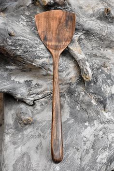 a wooden spoon sitting on top of a piece of wood