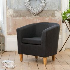 a black chair sitting in front of a wall with a heart shaped wreath on it