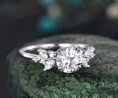 a three stone diamond ring on top of a rock