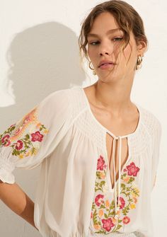 Add a bit of effortless charm to your wardrobe with the Auguste Coralie Blouse. This airy off-white blouse features beautiful floral embroidery for a bohemian-inspired look that you can dress up or down. 100% Viscose georgette V Neck With Optional Tie Closure Shirring Around Neck Raglan Puff Sleeves With An Elastic Cuff Semi-Sheer, Non-Stretch Fabric With A Soft Drape Hand Wash Cold Model is 5'10" Wearing a Size Small Blouse 2024 Trend, Sewing Cabinets, Embroidery Styles, Sewing Factory, Summer 2025, Fashion Top Outfits, Beautiful Summer Dresses, Clear Vision, Fashion Sewing Pattern