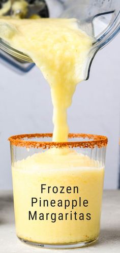 someone pouring pineapple margarita into a glass cup with the words frozen pineapple margaritas in it