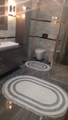 a bathroom with an oval rug on the floor