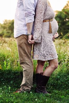 a man and woman standing next to each other in the grass