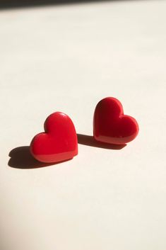 Pendientes de botón con forma de corazón mini en dos variantes, una con estampado en damero rojo cereza y rosa claro y otra en el mismo tono de rojo liso. Los materiales utilizados son la arcilla polimérica, un material muy ligero, difícil de romper, y muy resistente,  el acero inoxidable en las anillas y cierres y la resina para el toque brillante. Se recomienda tratarlos con delicadeza, y limpiarlos con un poco de agua o alcohol en un algodón, así como no bañarse con ellos para evitar el posible deterioro de las anillas, ganchos y aros. Todos los artículos están hechos a mano, por lo que podrían cambiar en forma y color ligeramente. Pesos y medidas: 3 gr ; 1,5cm Resin Heart Earrings For Gifts, Handmade Heart Earrings For Valentine's Day Gift, Handmade Heart-shaped Earrings, Adjustable Red Heart Earrings For Gift, Handmade Round Heart Earrings For Gift, Handmade Round Heart Earrings As Gift, Heart Shaped Earrings For Gifts, Spain, Stud Earrings