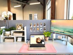 a laptop computer sitting on top of a white desk next to a monitor and keyboard