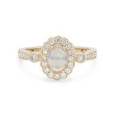 an opal and diamond ring in yellow gold, set with a white stone surrounded by small diamonds