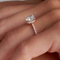 a woman's hand with a diamond ring on her finger and an engagement band