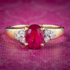 A fabulous Art Deco inspired ring claw set with a gorgeous, cherry-pink synthetic ruby in the centre (approx. 1.5ct) flanked by triangular shoulders set with three twinkling white sapphires (approx. 0.30ct total).  Ruby has been a favourite of kings and emperors throughout history and is considered a stone of the heart. Its fiery pink/ red hue is symbolic of passion and said to bring good fortune in love and provide long lasting happiness and vitality to any relationship. The sleek band is all 9 Ruby Wedding Anniversary Gifts, Antique Ruby Ring, Ruby Wedding Anniversary, Ruby Wedding, Pink Sapphire Ring, Golden Ring, Ruby Sapphire, Antique Pink, Vintage Jewels