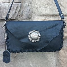 Nwt A Thick Black Leather, Small Crossbody Bag From Delila With A Stunning Antique Silver Medallion With Scrollwork. It Has A Rough Cut Flap With A Hidden Magnetic Closure. The Long Crossbody Strap Is Detachable And Drops 24.5". The Edges Are Trimmed With Black Suede Lacing And The Interior Is The Raw Suede With 3 Card Slots. It Measures 9" Wide, 5" In Height And Minimal Depth. A Wonderful Accent For Western Attire, A Boho Look Or Just A Great Contemporary Style. Detach The Strap And Use It As A Silver Leather Clutch Shoulder Bag, Leather Clutch With Silver-tone Hardware For Daily Use, Silver Clutch With Detachable Strap For Everyday Use, Black Clutch With Silver-tone Hardware For Everyday Use, Silver Leather Clutch Bag, Silver Soft Leather Crossbody Bag, Silver Shoulder Clutch For Everyday Use, Everyday Pouch Clutch With Silver-tone Hardware, Everyday Crossbody Clutch With Silver-tone Hardware