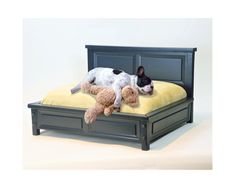 a dog laying on top of a bed with a teddy bear