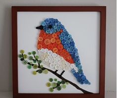 a colorful bird sitting on top of a button covered tree branch in a brown frame