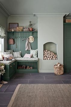 a room with green painted walls and wooden furniture, including a bench in the corner