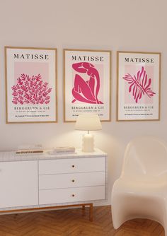 three posters on the wall above a white dresser