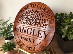 a wooden sign sitting on top of a table next to potted plants and succulents