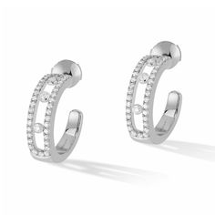 Pared down style and modern, these white gold pave diamond hoop earrings are the best everyday companions of a woman for a glamorous and stylish look. Diamond jewels of the Move Joaillerie collection, these diamond jewels are recognizable by the diamonds in motion. Three luminous stones on each ear, perfect symbols of the love of yesterday, today and tomorrow. In this aerial pave version, these 18k white gold diamond hoop earrings will wrap up the face with a special glow. Diamonds are 1/2ctw, G in color, and VS in clarity. Earrings measure 15mm in diameter. Messika Style #: 04993-WG White Gold Hoop Earrings, Gold Diamond Hoop Earrings, White Gold Diamond Earrings, Luxury Jewelry Brands, White Gold Hoops, Diamond Jewel, Classic Bracelets, Mini Hoop Earrings, Gold Diamond Earrings