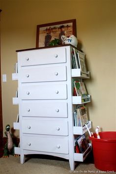 there is a white dresser with many books on it