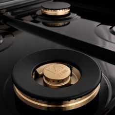 closeup of the knobs on an electric stove with gold trim and black burners