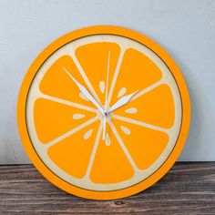 a clock made out of an orange slice on a wooden table with a white face