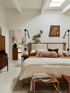 a bedroom with white walls and wooden furniture