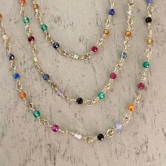 the multi - colored beaded necklace is attached to a gold plated metal chain