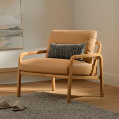 a chair with a pillow and slippers on the floor in front of a painting