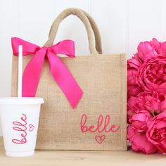 a pink flower next to a burlock bag and cup