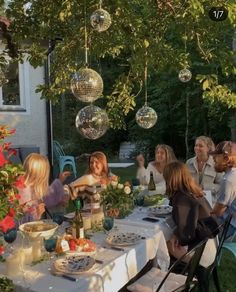 a group of people sitting around a table with food and drinks