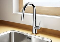 a stainless steel kitchen sink and faucet in front of a window