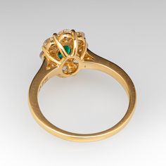 a gold ring with an emerald and diamond center