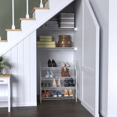 an open closet under the stairs with shoes and other items