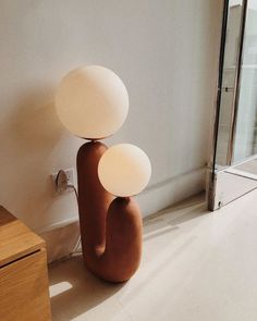 two lamps sitting on top of a wooden table next to a glass door in a room