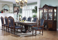 a dining room table with chairs and a china cabinet in the corner, along with a chandelier