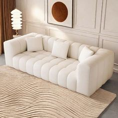 a white couch sitting on top of a rug in a living room