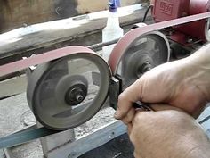 a man is working on a machine in a factory or workshop with his hand holding the wheel